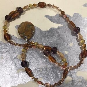 Stone central pendant within glass and lucite beaded stand necklace to lobster